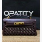 JW PEI Noor Top Handle Bag in dark red is a vegan leather bag featuring gold hardware and a woven design.