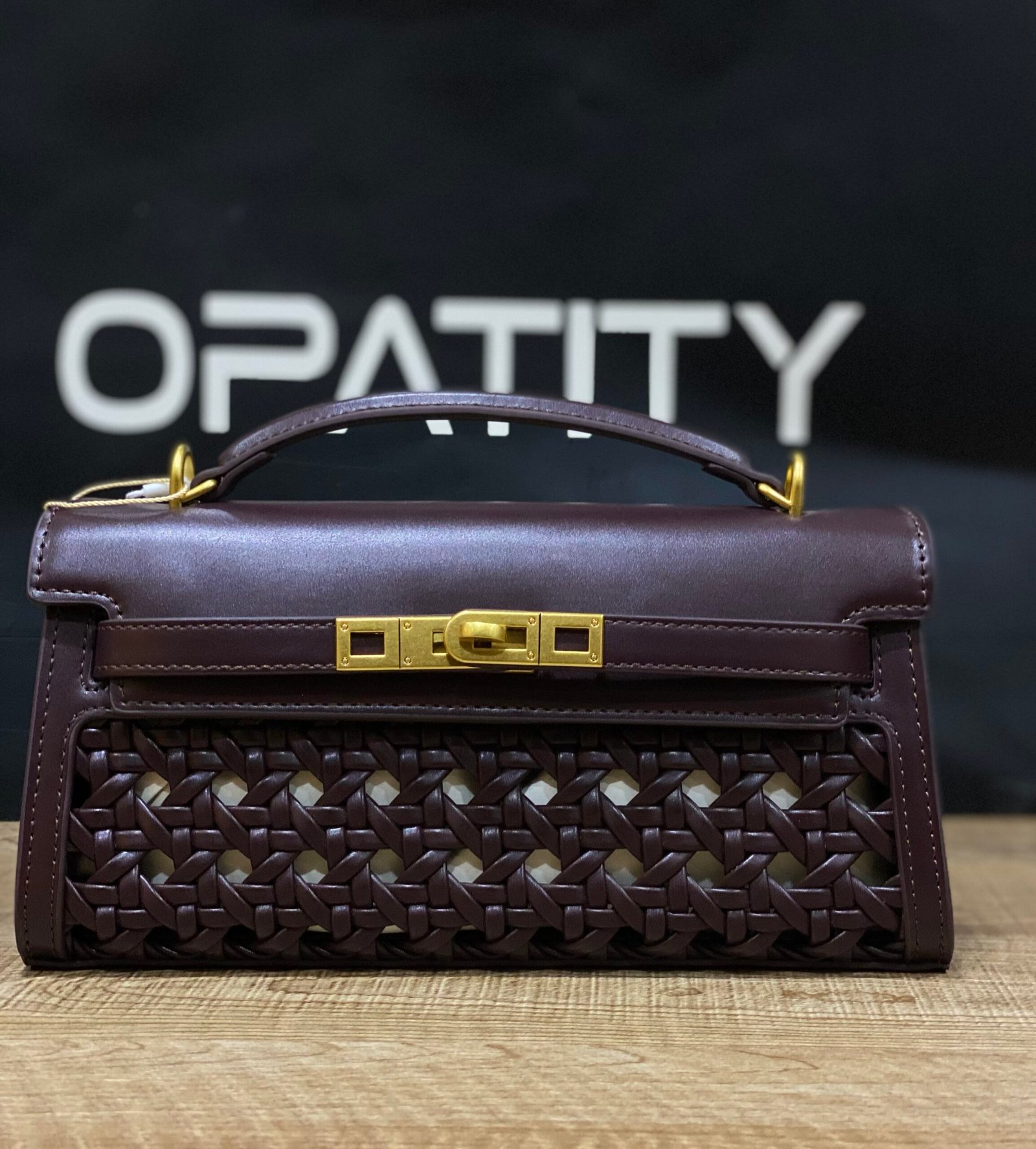 img_5786 JW PEI Noor Top Handle Bag in dark red is a vegan leather bag featuring gold hardware and a woven design. - Image 1