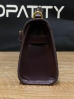 JW PEI Noor Top Handle Bag in dark red is a vegan leather bag featuring gold hardware and a woven design. - Image 6