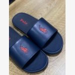 Polo Ralph Lauren Cayson Slides in a classic navy blue and red colorway. These lightweight pool slides are crafted with a synthetic leather upper strap lined with soft, cushioned fabric for comfortable wear.